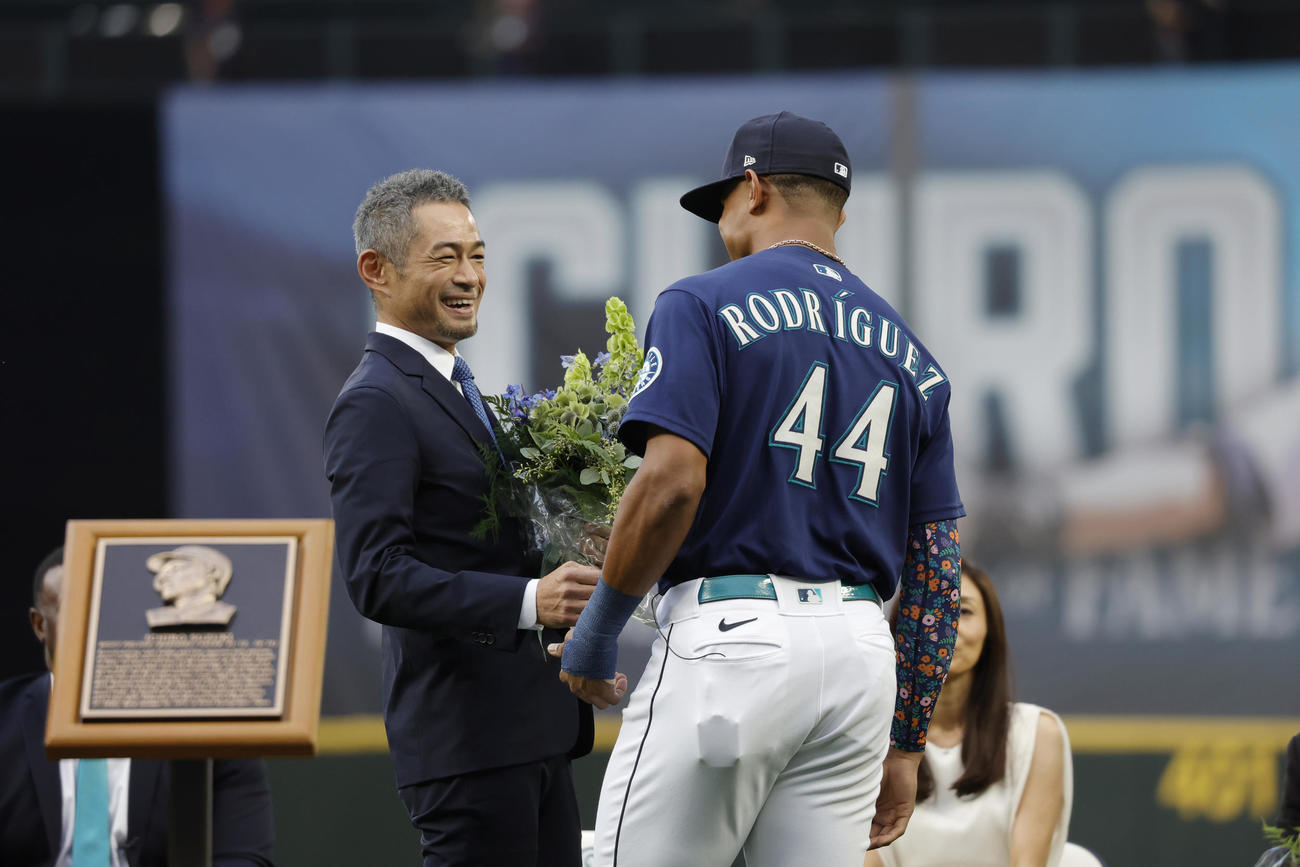 セレモニーでフリオ・ロドリゲス（右）から花束を贈呈され、笑顔を見せるイチロー氏（AP）