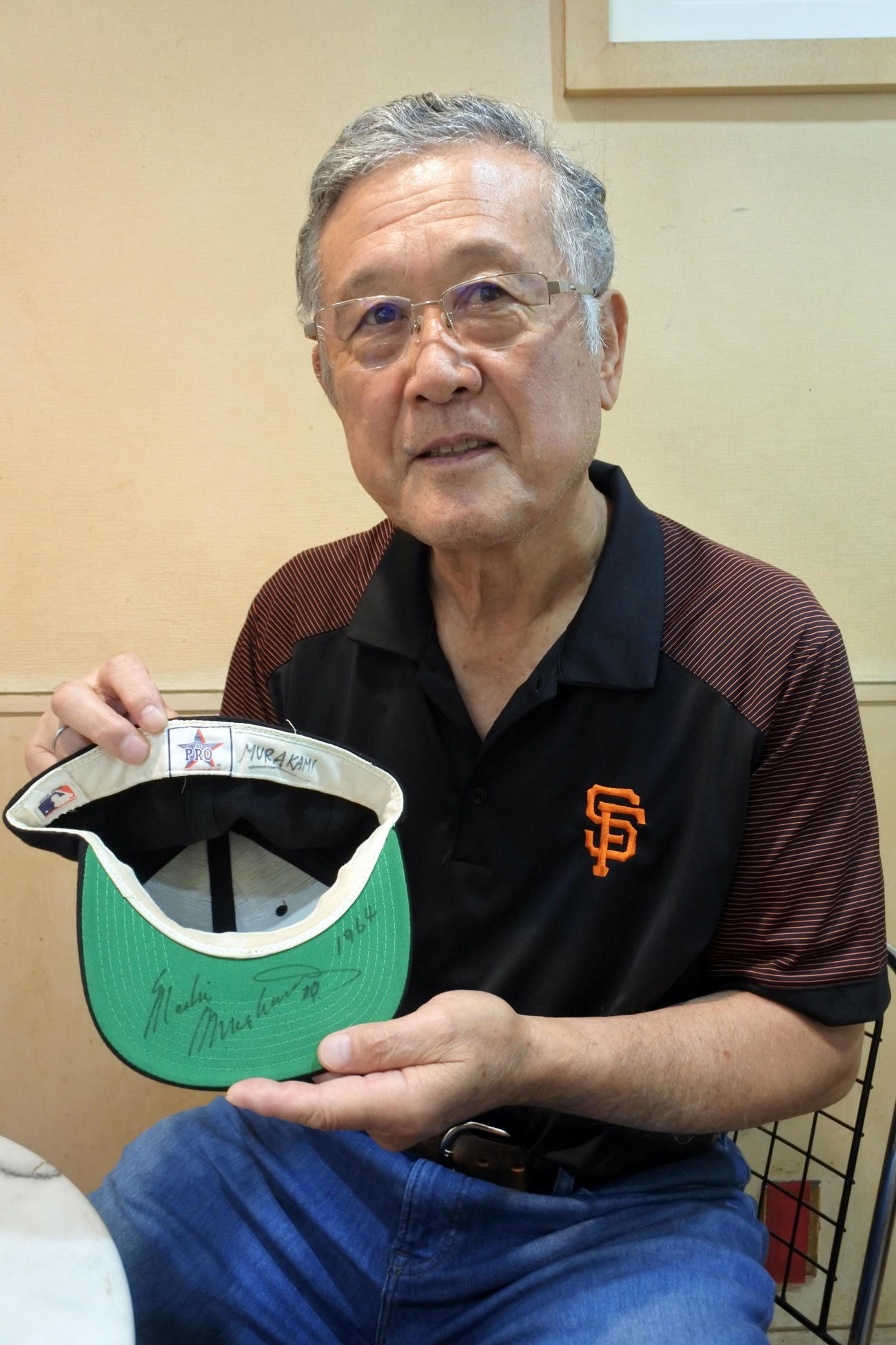 日本人メジャー初勝利時にかぶっていた、ジャイアンツ1年目の帽子を手にする村上氏