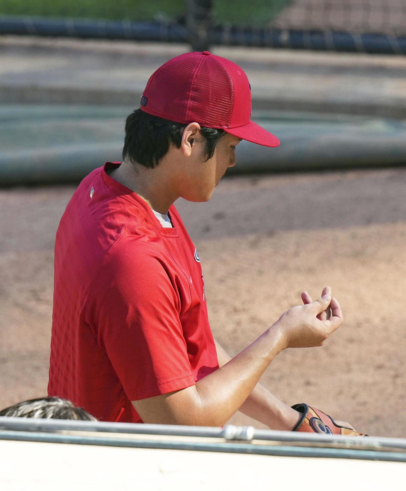 試合前、ブルペンでの投球練習中に指を見るエンゼルス・大谷＝アナハイム（共同）