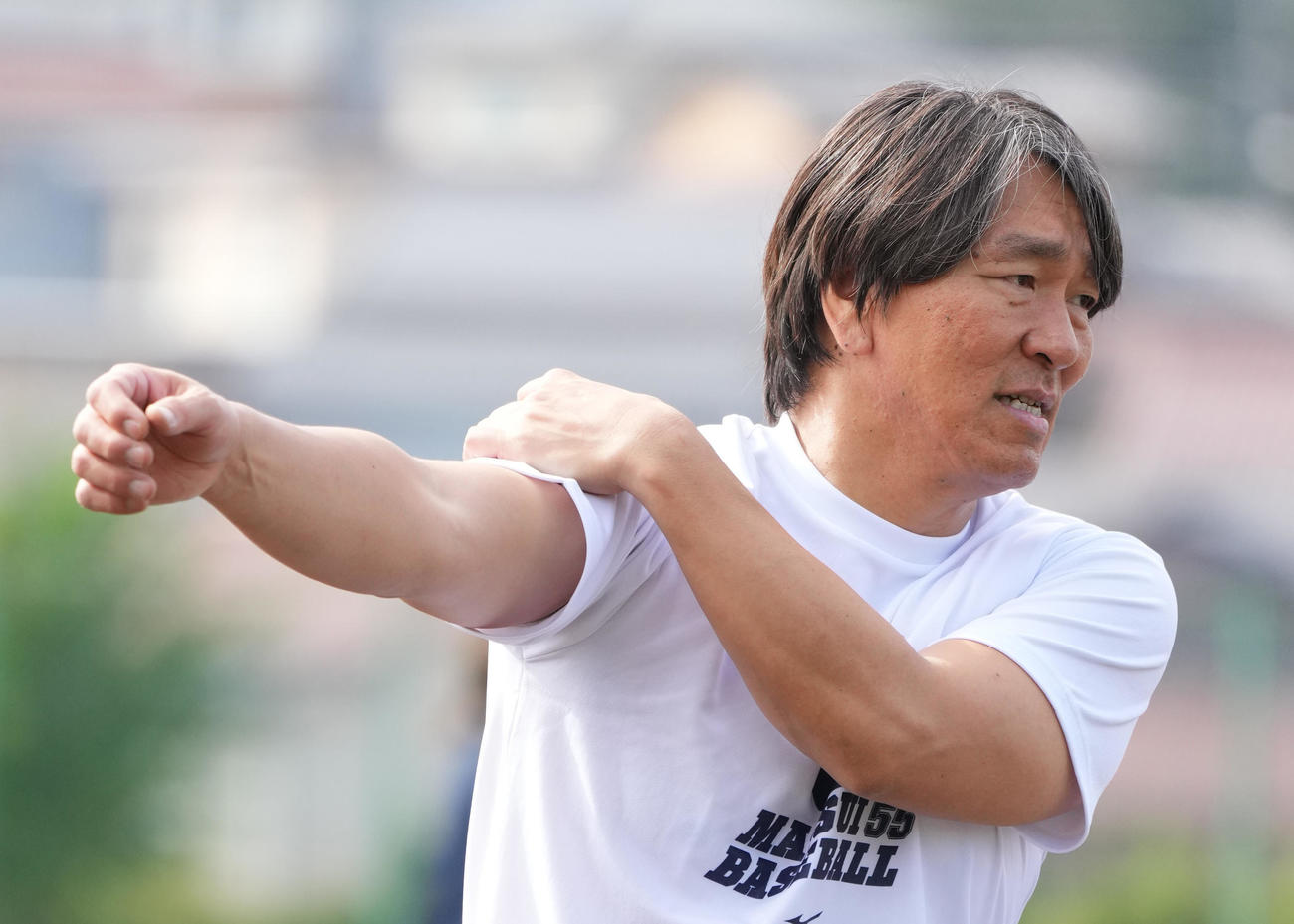 野球教室で打撃投手を務める松井氏は、投球の合間に腕を回す（撮影・菅敏）