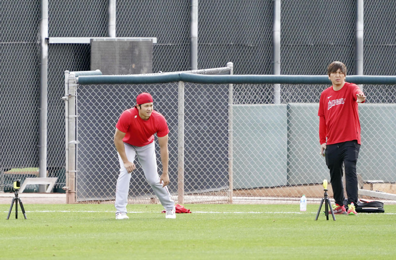 球団施設でダッシュするエンゼルス大谷。右は水原通訳（共同）