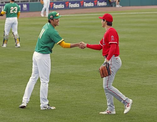 試合前に握手を交わすアスレチックス藤浪（左）とエンゼルス大谷（共同）