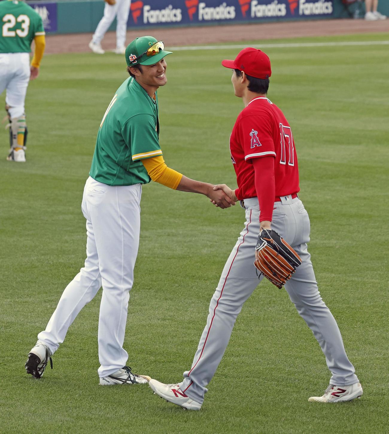 試合前に握手を交わすアスレチックス・藤浪（左）とエンゼルス・大谷＝メサ（共同）
