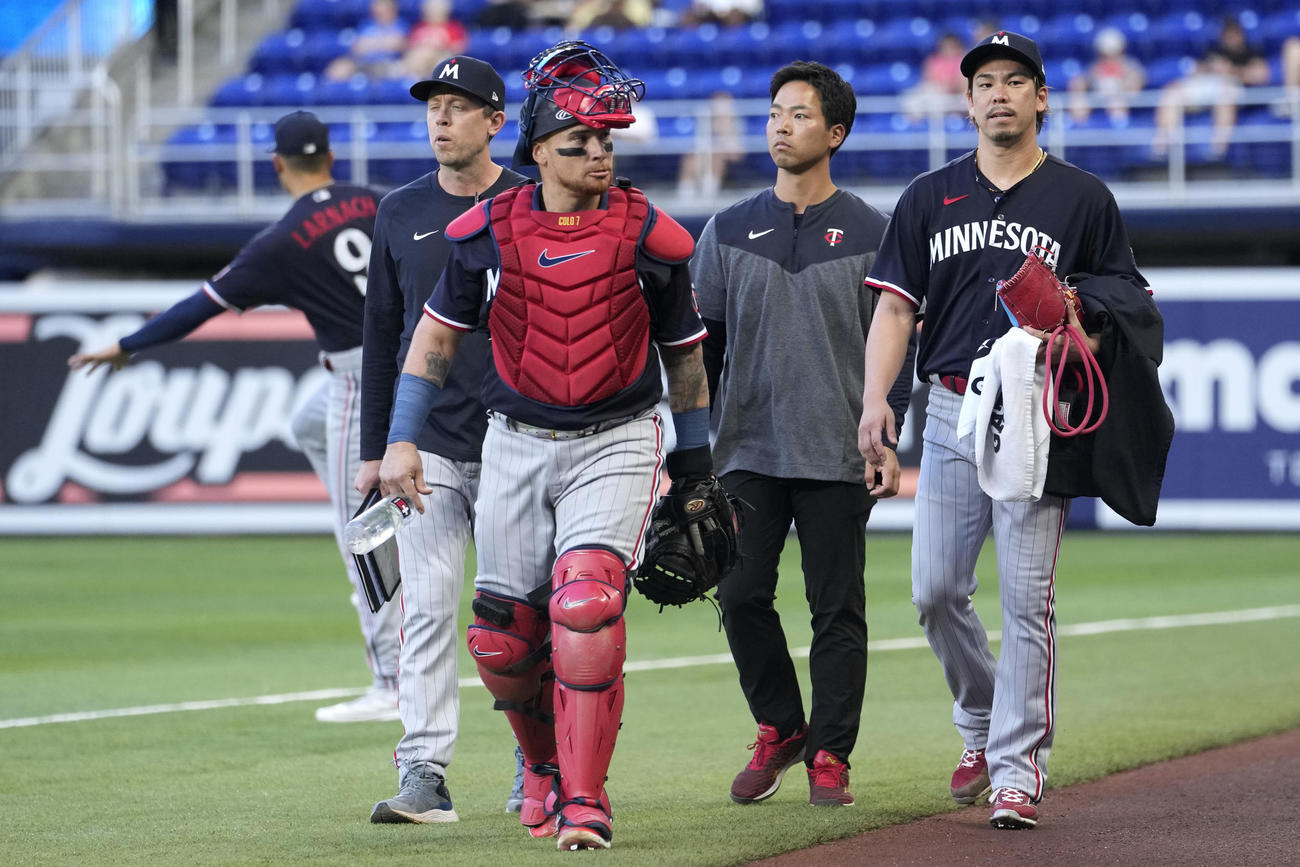 マリナーズ戦の開始前、ツインズ前田健太（右）はバスケス（右から3人目）と言葉をかわしてベンチへ向かう（AP）