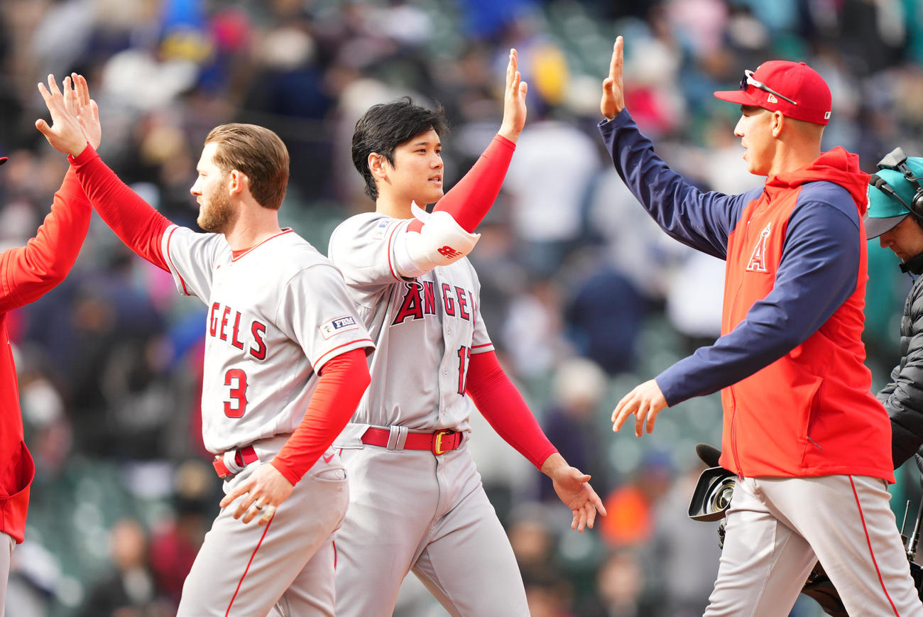 マリナーズに勝利し、今季初勝利を挙げたエンゼルス大谷（中央）は、ナインとタッチをする（撮影・菅敏）