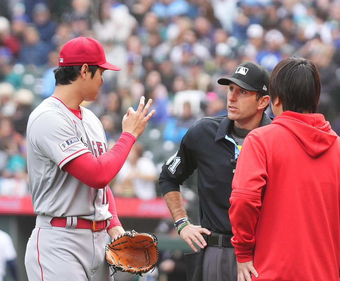 マリナーズ対エンゼルス　1回にピッチクロック違反を取られたエンゼルス大谷（左）はベンチに戻る際に球審と話す（撮影・菅敏）