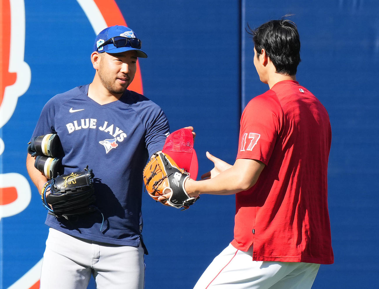 エンゼルス対ブルージェイズ　試合前、ブルージェイズ菊池（左）から帽子を受け取るエンゼルス大谷（撮影・菅敏）