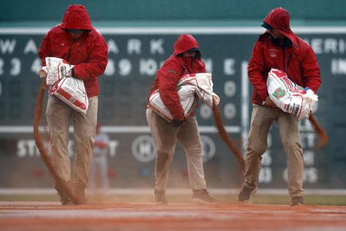 レッドソックス対エンゼルス 2回、雨が強まりグラウンドに砂を入れる整備員(AP)