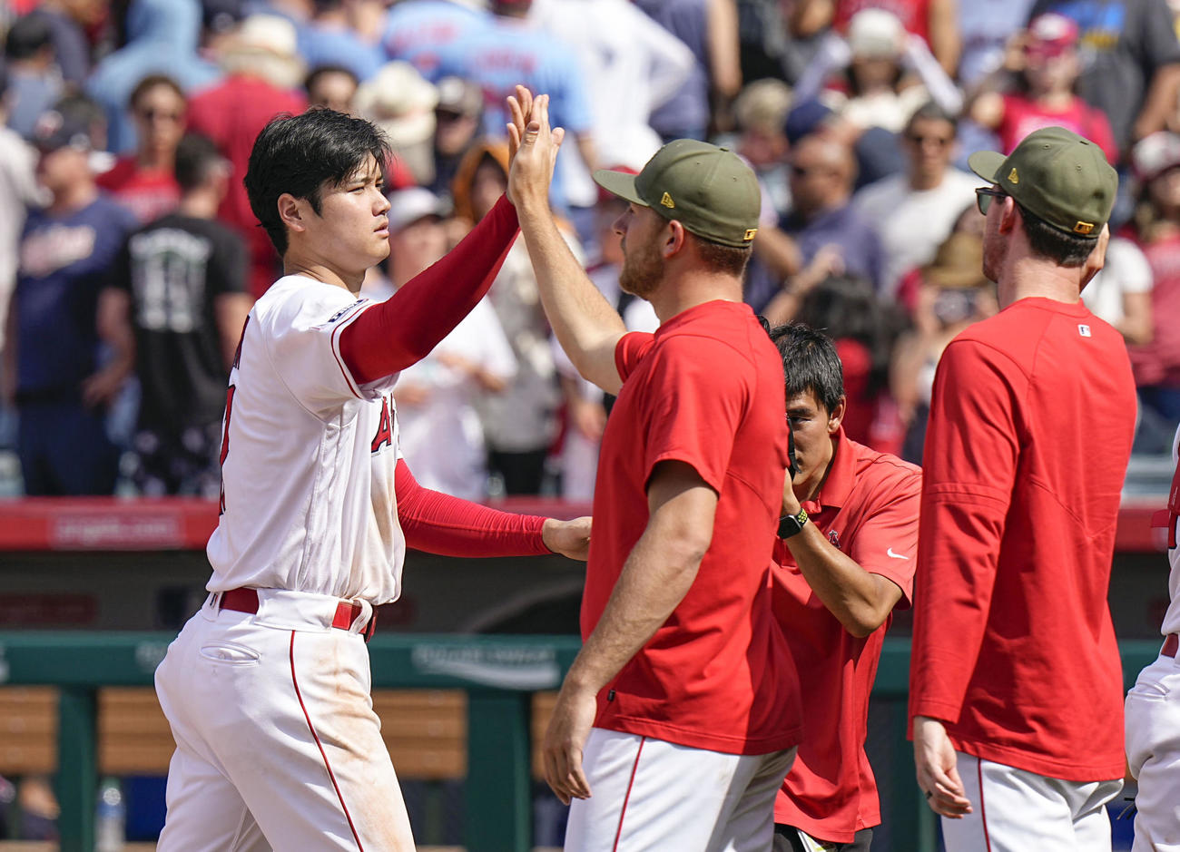 ツインズに勝利し、チームメートとタッチを交わすエンゼルス・大谷翔平（共同）