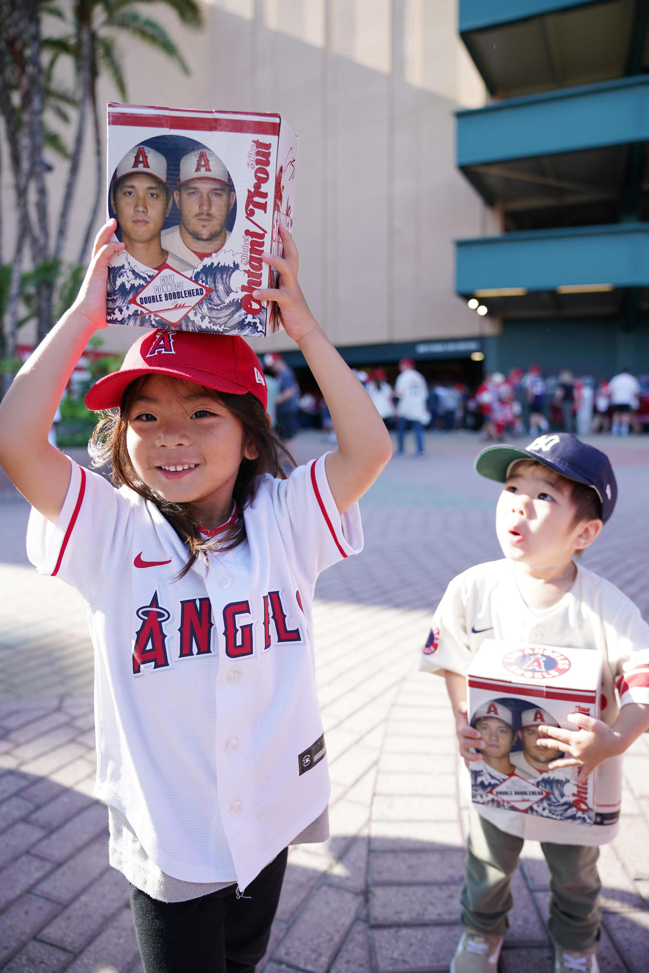 エンゼルス対ダイヤモンドバックス　試合前、先着入場者に配られる大谷とトラウトのボブルヘッドを手に笑顔を見せるエンゼルスファン（撮影・垰建太）