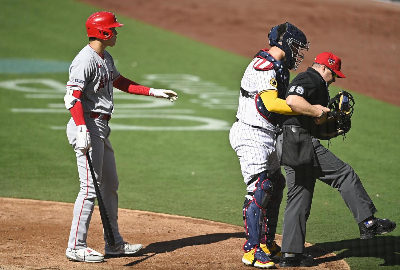 パドレス戦の4回、ファウルが球審（右）に当たり、心配するエンゼルス・大谷（左）（共同）