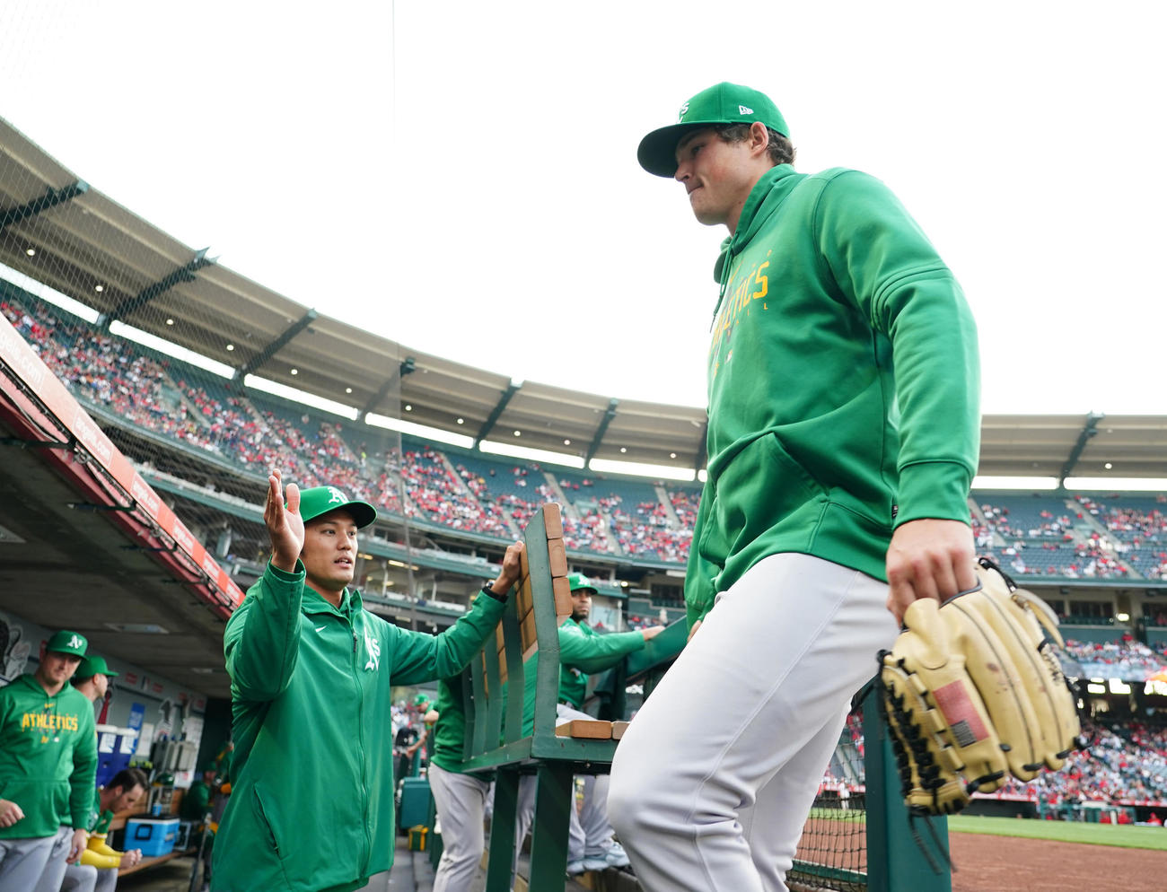 エンゼルス対アスレチックス　試合前、ブルペンからベンチに戻る先発のミラー（右）をタッチで迎える藤浪（2023年4月25日）