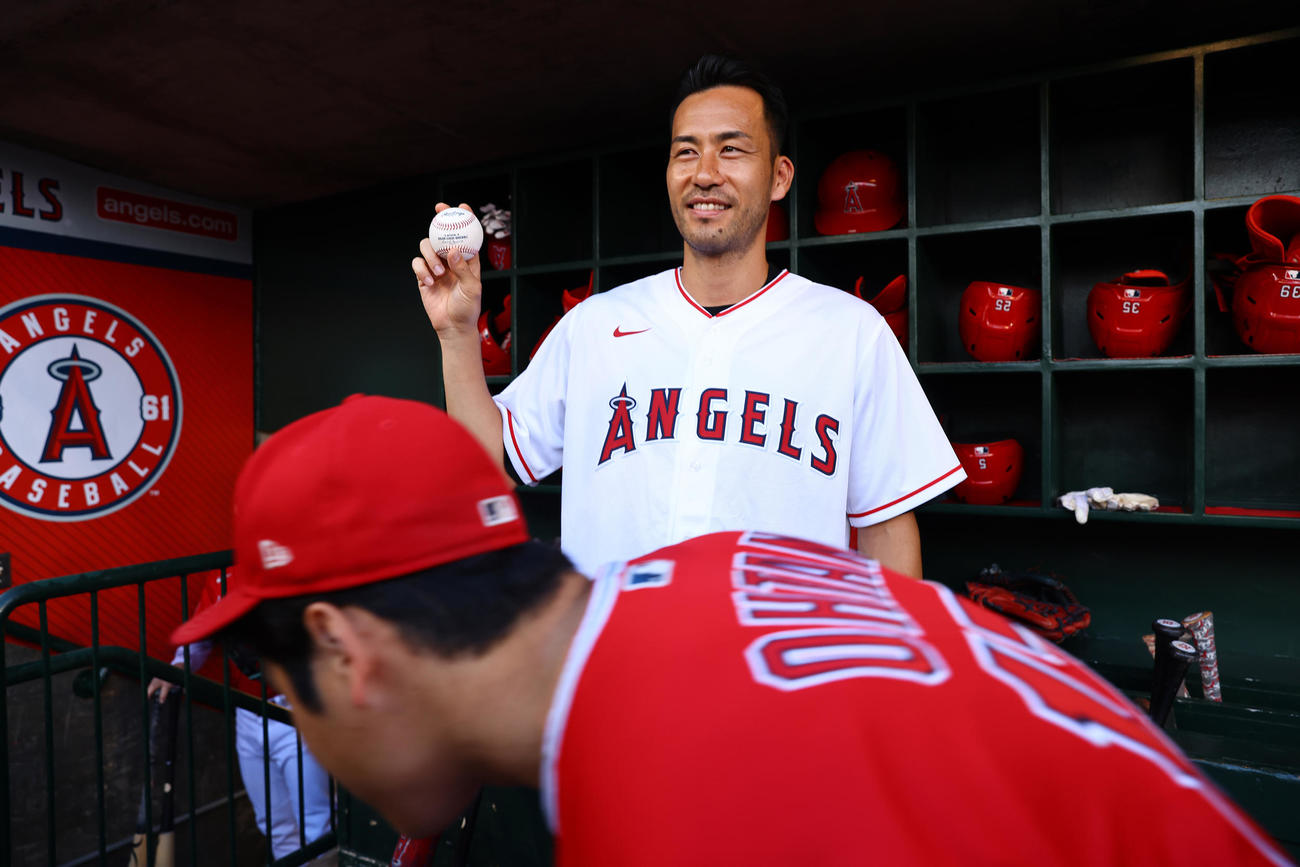 エンゼルス対ジャイアンツ　試合前、始球式を行うロサンゼルス・ギャラクシーの吉田が記念写真を行う前を気遣い身を屈めベンチ裏へと向かうエンゼルス大谷（撮影・垰建太）