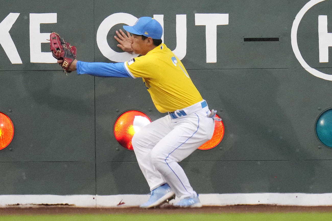 ロイヤルズ戦、2回にフェンス際でジャンピングキャッチを試みる吉田（AP）