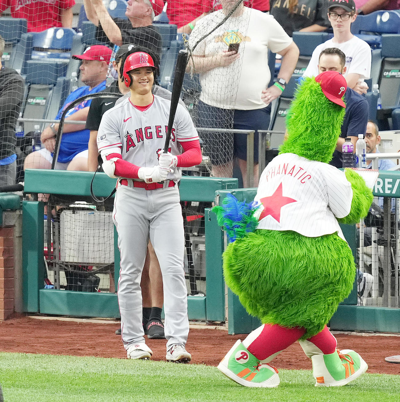 フィリーズ対エンゼルス　試合前、似顔絵を描く球団マスコットのファナティック（右）を前に笑顔を見せる大谷（撮影・菅敏）