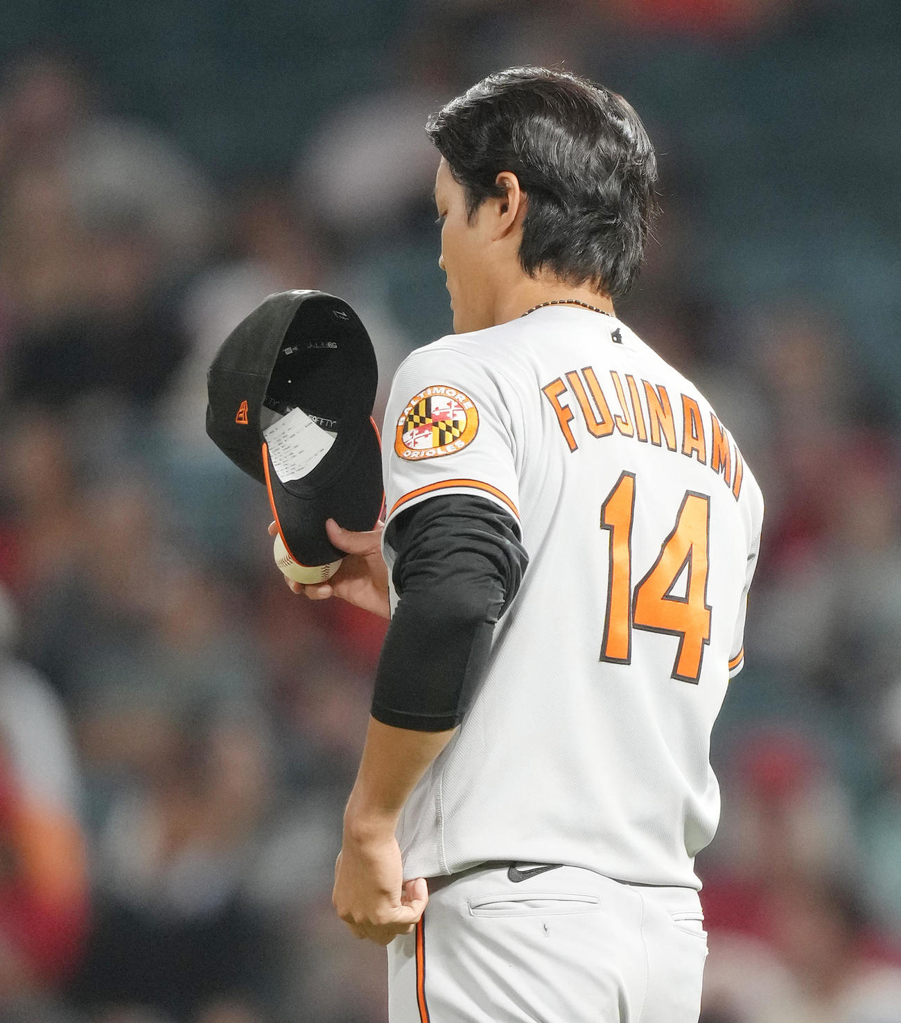 エンゼルス対オリオールズ　8回、1イニングに登板し、投球に合間に帽子の内側を見つめるオリオールズ藤浪（撮影・菅敏）