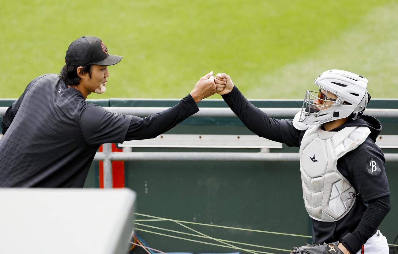試合前、ブルペンでの投球練習を終え、捕手とタッチを交わすオリオールズ・藤浪＝ボルティモア（共同）