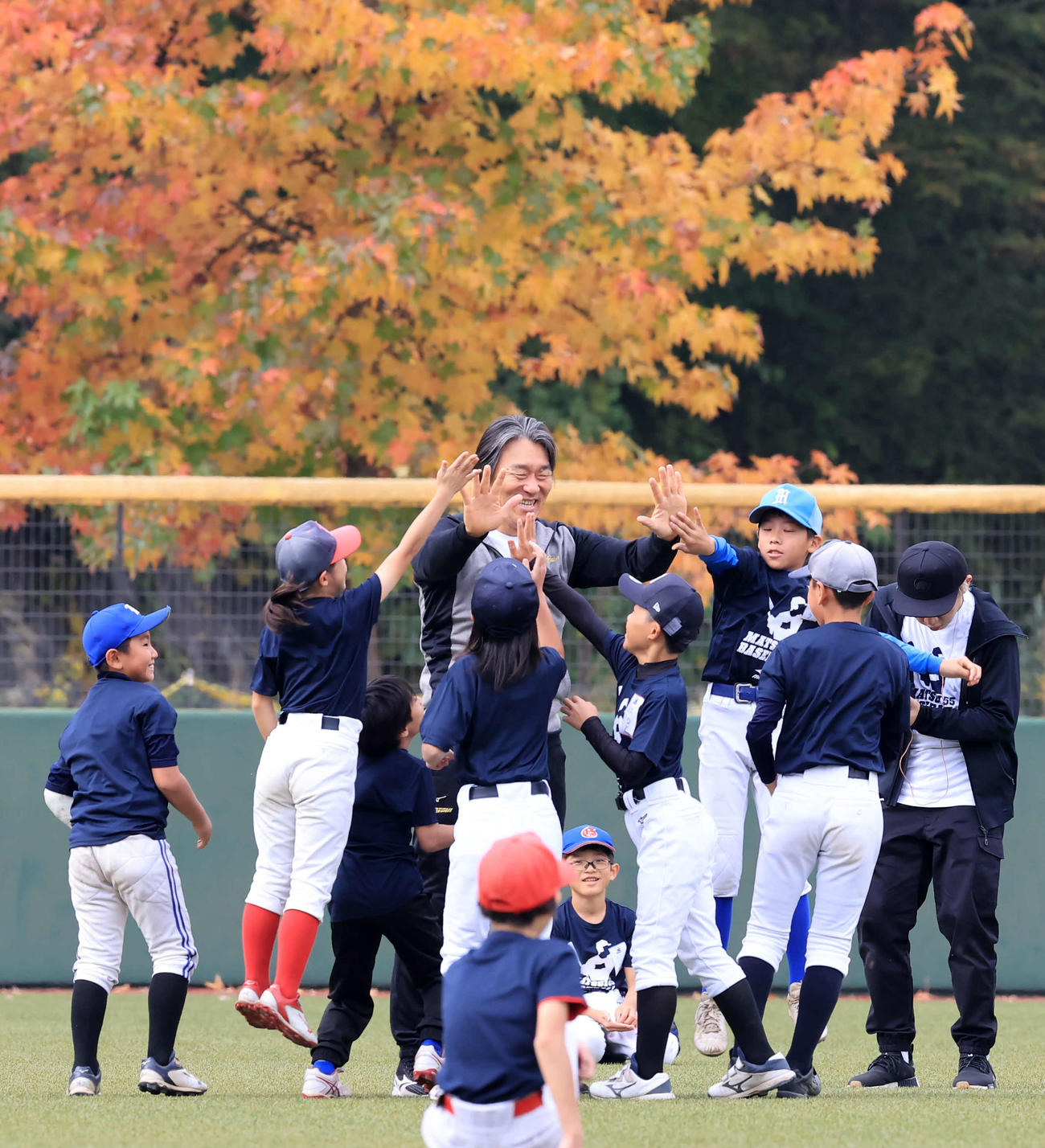 「松井秀喜野球教室」で、紅葉を背に子どもたちとハイタッチする松井秀喜氏（撮影・浅見桂子）