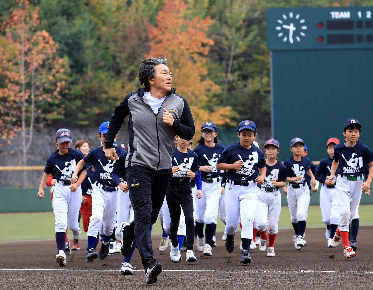 「松井秀喜野球教室」で、紅葉を背に子どもたちと走る松井秀喜氏（撮影・浅見桂子）