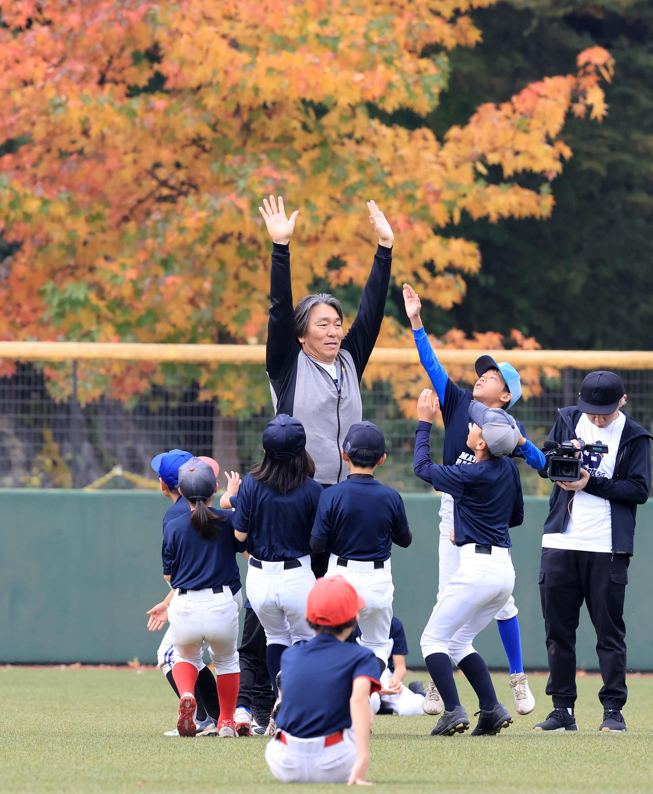「松井秀喜野球教室」で、紅葉を背に子どもたちとハイタッチする松井秀喜氏（撮影・浅見桂子）