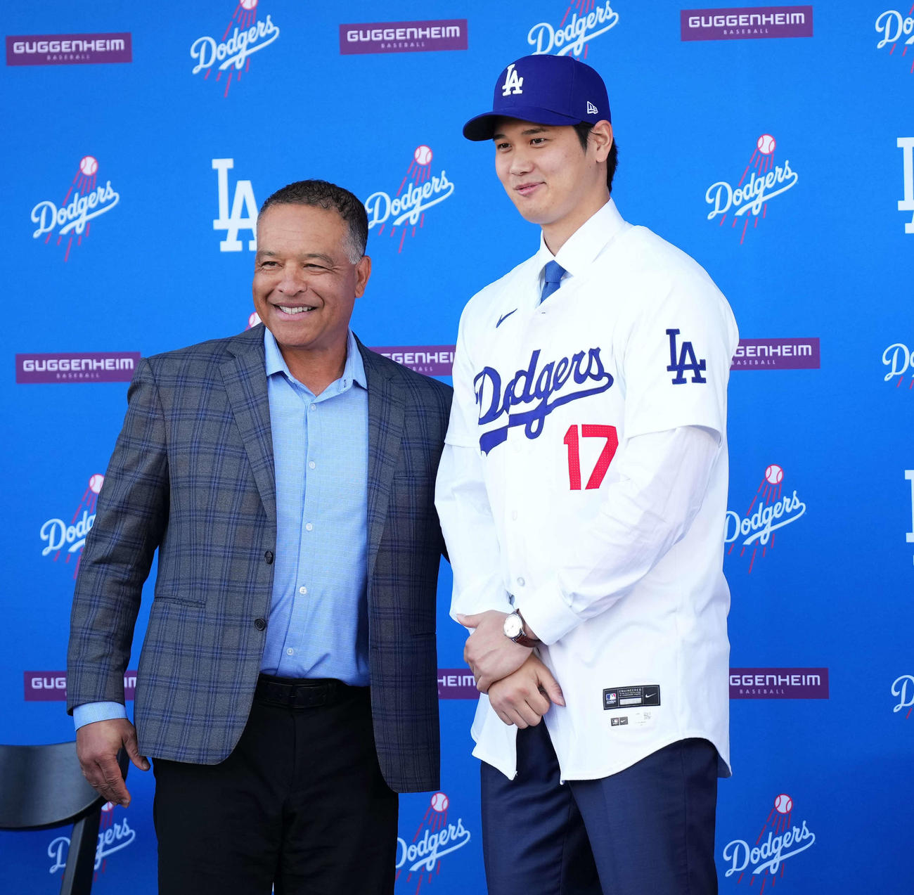 入団会見でドジャースのユニホームに袖を通し、ロバーツ監督と笑顔を見せる大谷（撮影・菅敏）
