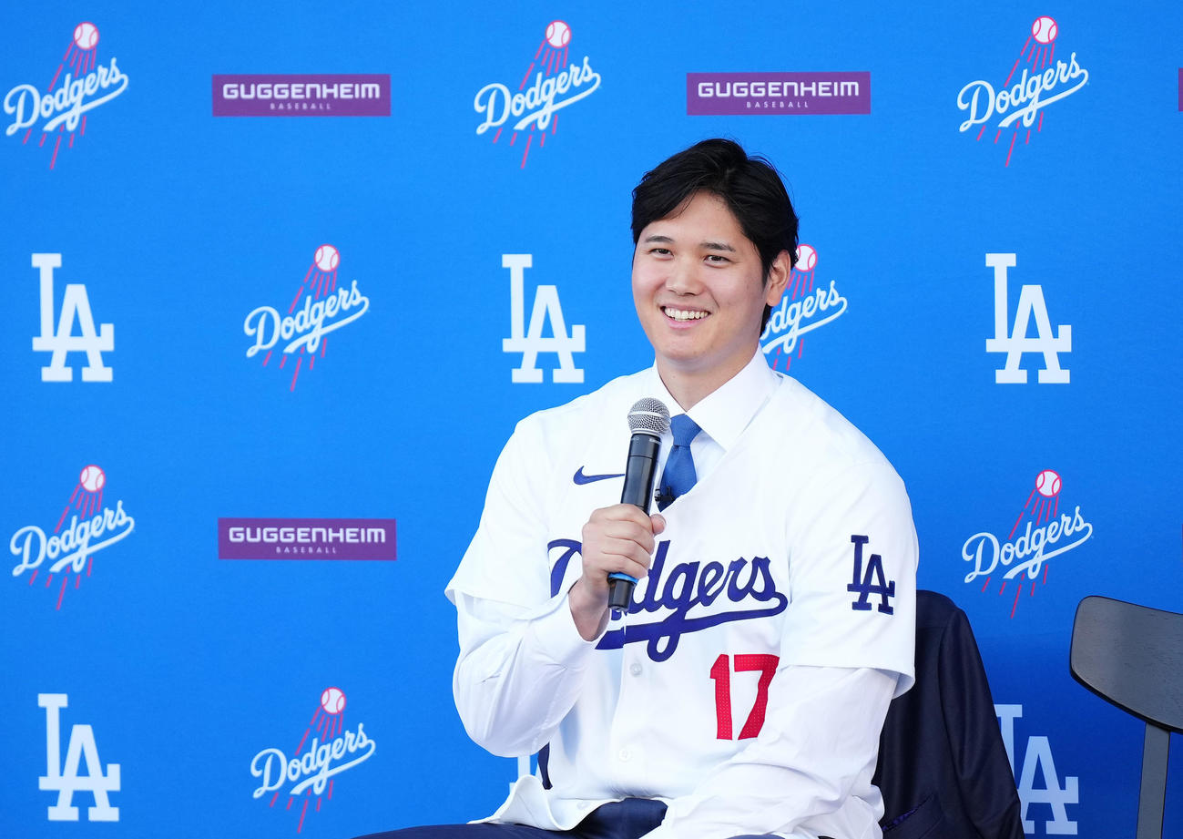 ドジャース入団会見でユニホームに袖を通し、記者の質問に答える大谷（撮影・菅敏）