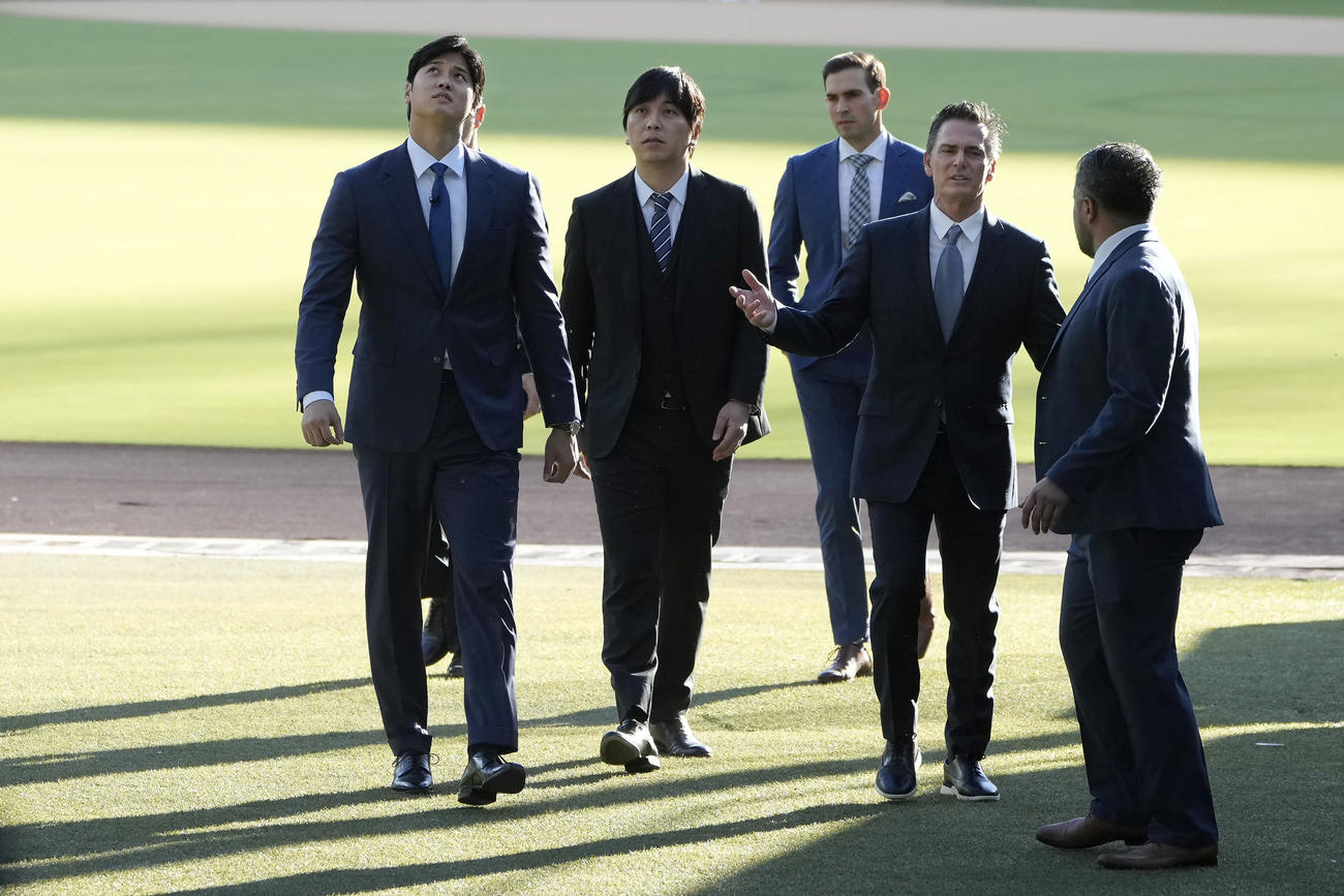 ドジャースタジアムのグラウンドを歩く大谷翔平（左）（AP)