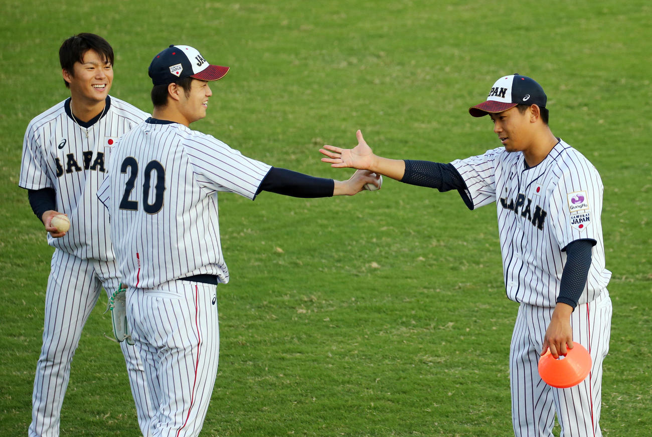 WBSC世界野球プレミア12　日本対プエルトリコ　試合前、山本（左）、甲斐野（中央）に投球のイメージを身ぶり手ぶりで伝える今永（2019年11月6日撮影）