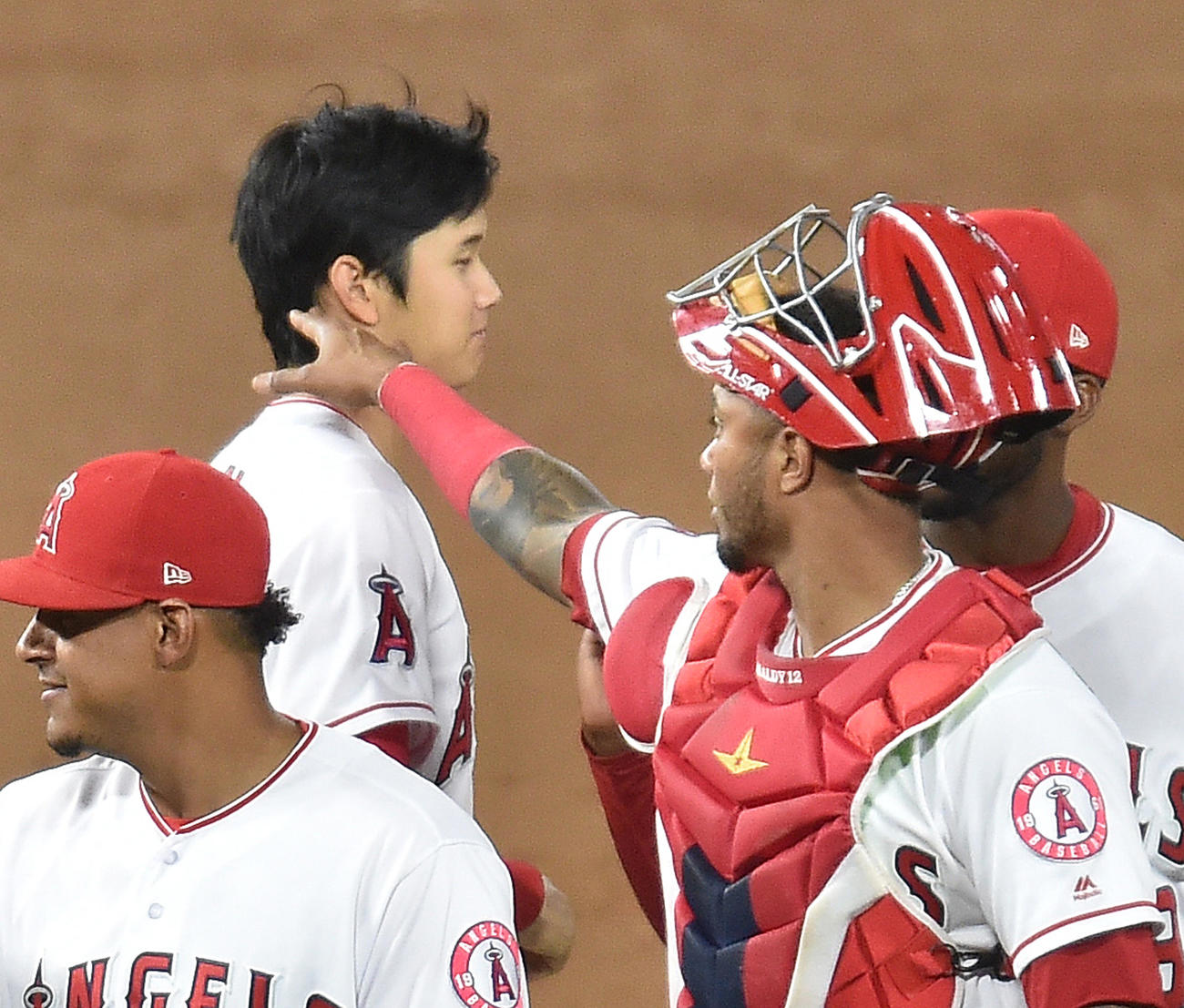 勝利し、ナインをタッチで迎えるも捕手マルドナド（右）に首をチョップされる大谷（2018年5月3日撮影）