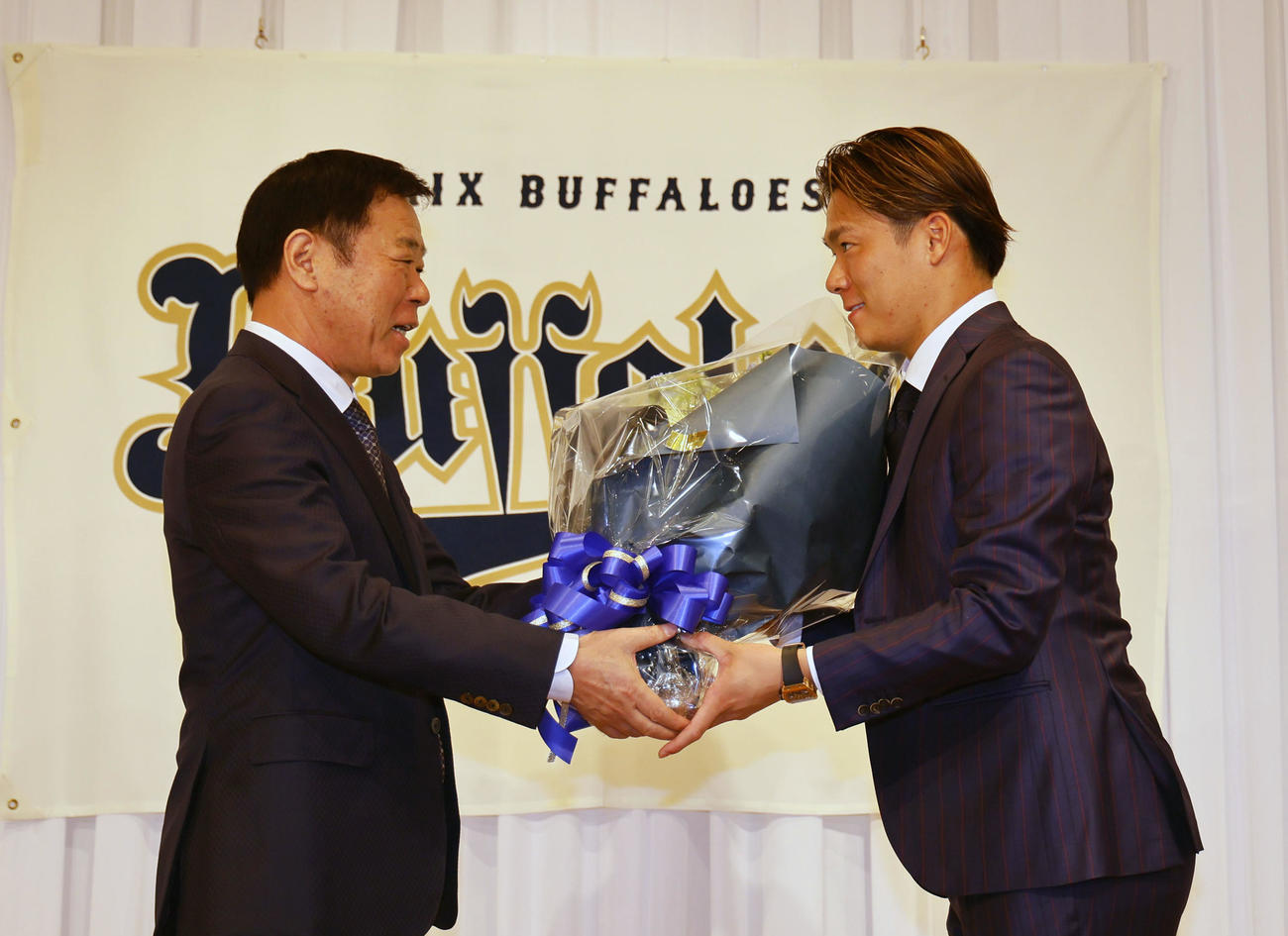 記者会見を終え、オリックス福良GM（左）から花束を贈られる山本（撮影・藤尾明華）