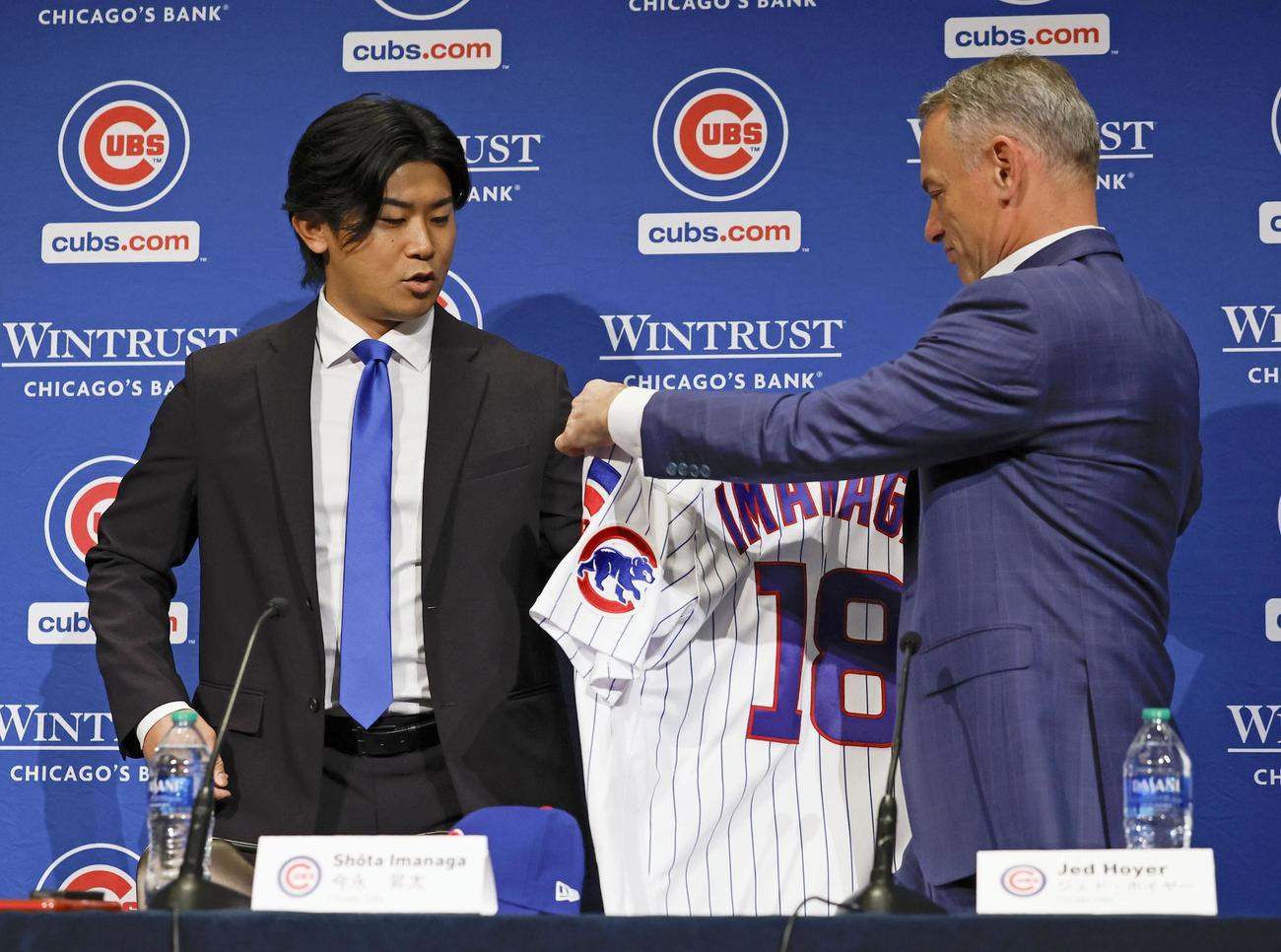 米大リーグ、カブスの入団記者会見で、ホイヤー編成本部長（右）にユニホームを着せてもらう今永昇太投手（共同）