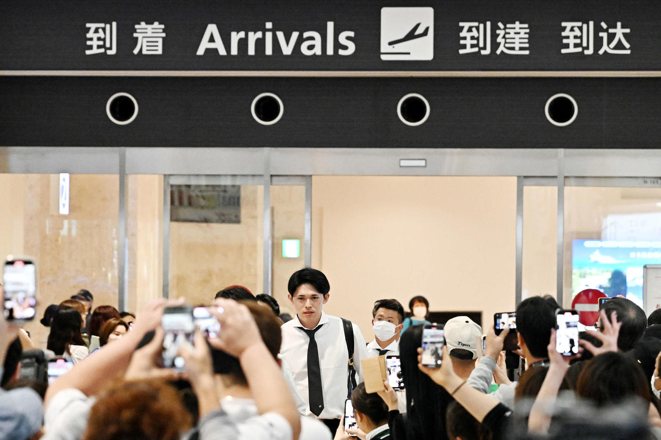 石垣空港に到着しファンに囲まれるロッテ佐々木（撮影・滝沢徹郎）