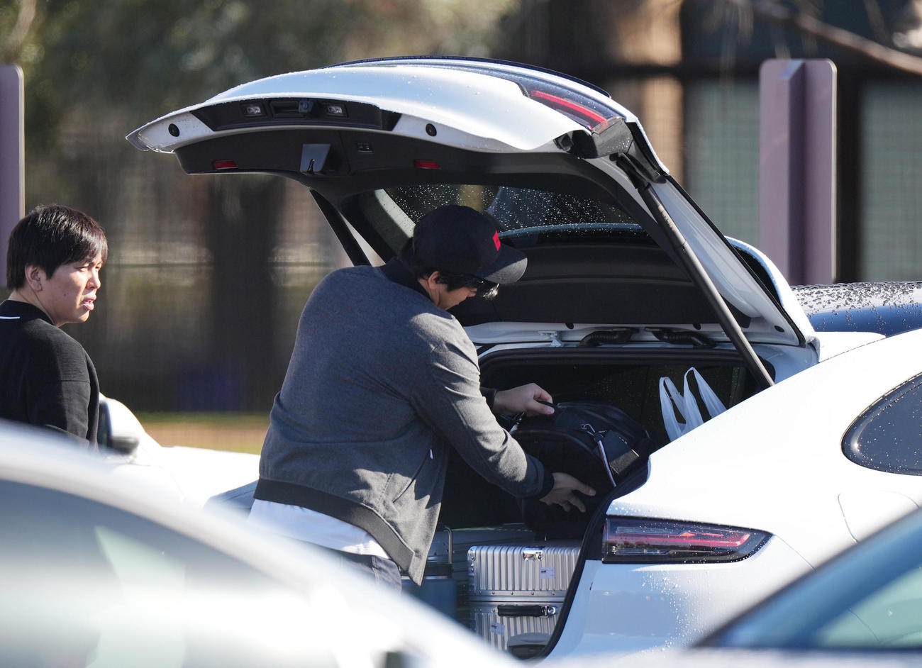 キャンプインを翌日に控え調整したドジャース大谷は、車のトランクを開けて荷物を入れる。左は水原通訳（撮影・菅敏）