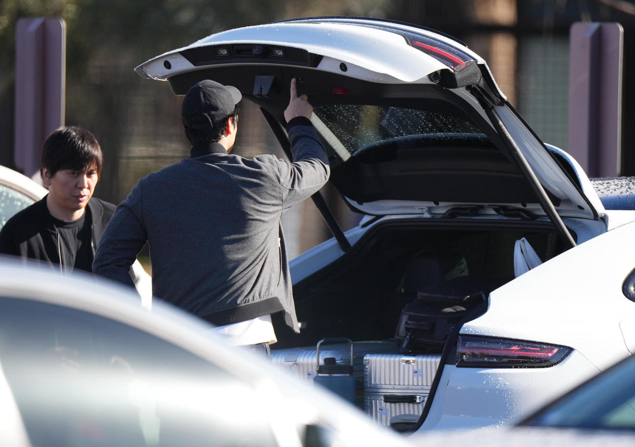 キャンプインを翌日に控え調整したドジャース大谷は、荷物を入れたトランクを閉める。左は水原通訳（撮影・菅敏）