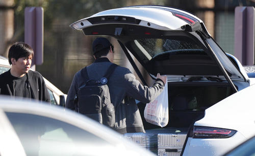 キャンプインを翌日に控え調整したドジャース大谷は、車のトランクを開けて荷物を入れる。左は水原通訳（撮影・菅敏）