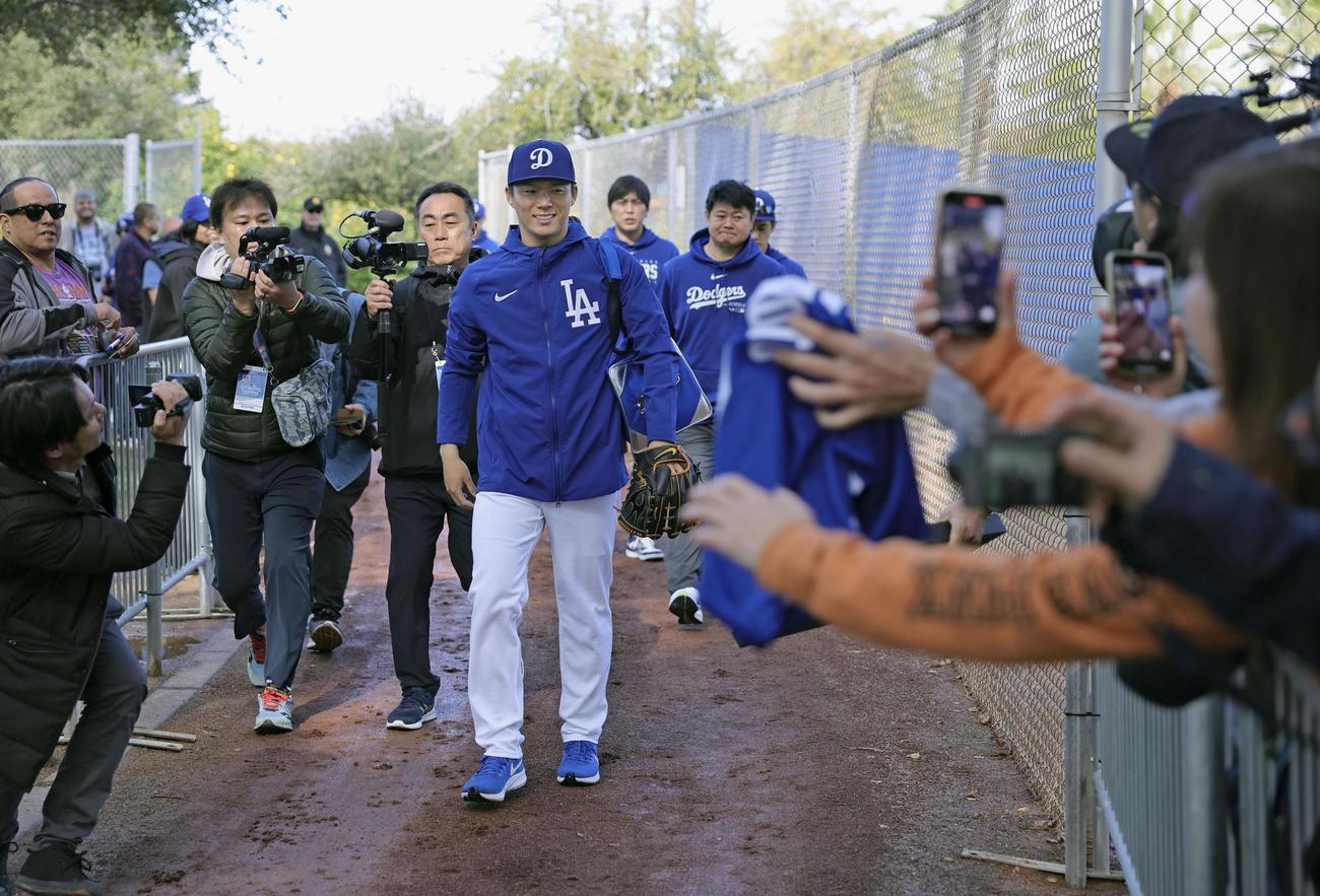 キャンプ初日、ファンの歓声を受けながら練習に向かう米大リーグ、ドジャースの山本由伸（共同）
