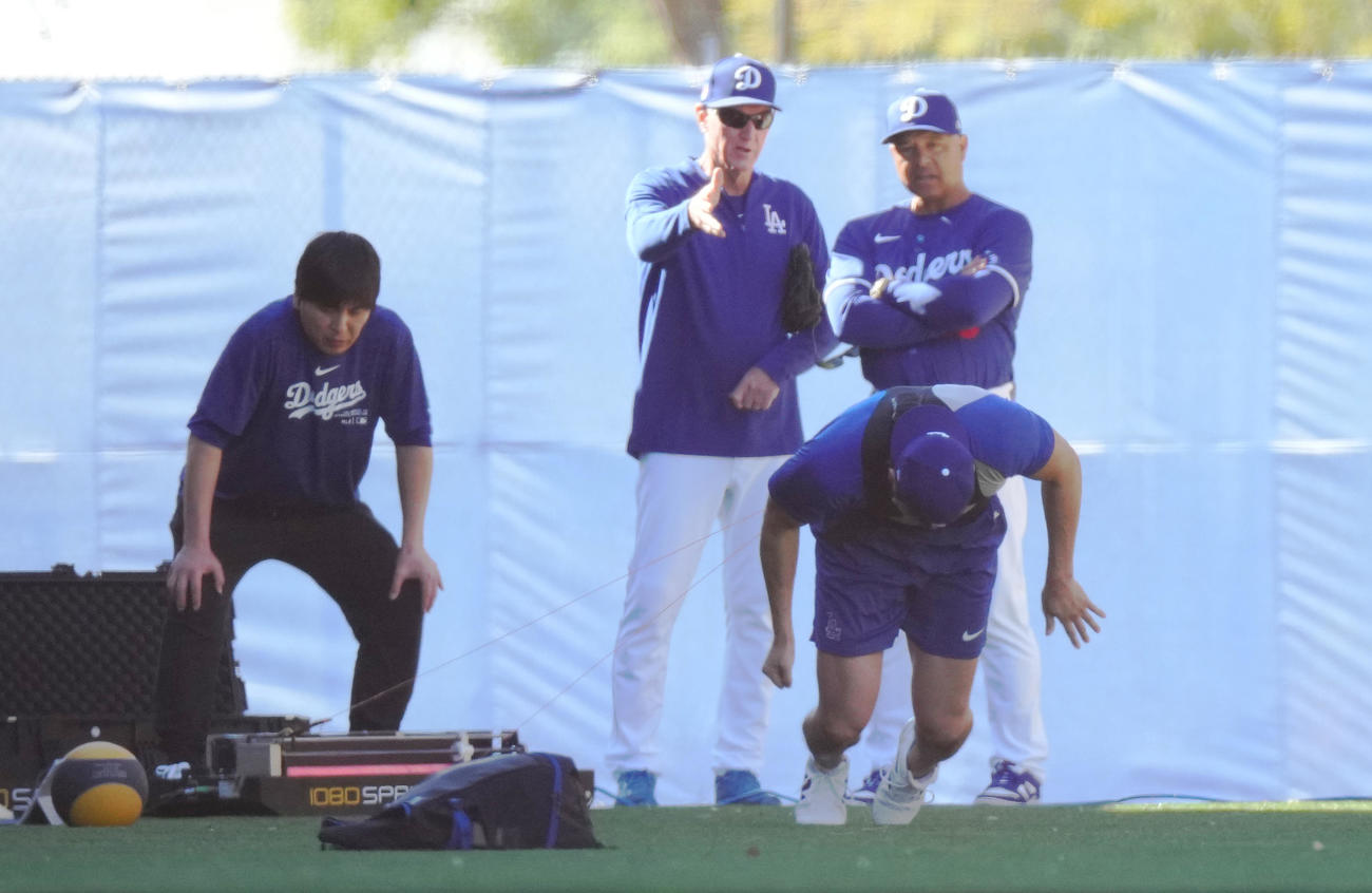 測定器のワイヤをつけ、ダッシュをするドジャース大谷（手前）。後方左から水原通訳、レネキー氏、ロバーツ監督（撮影・菅敏）