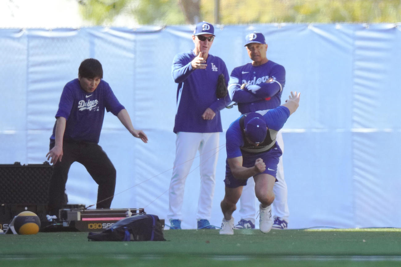 測定器のワイヤをつけ、ダッシュをするドジャース大谷（手前）。後方左から水原通訳、レネキー氏、ロバーツ監督（撮影・菅敏）