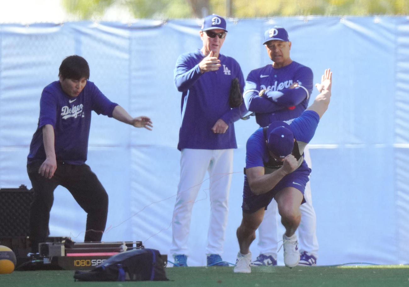 測定器をつけダッシュをするドジャース大谷（手前）は、突然ワイヤが切れてしまい体勢を崩してしまう。後方左から水原通訳、レネキー氏、ロバーツ監督（撮影・菅敏）