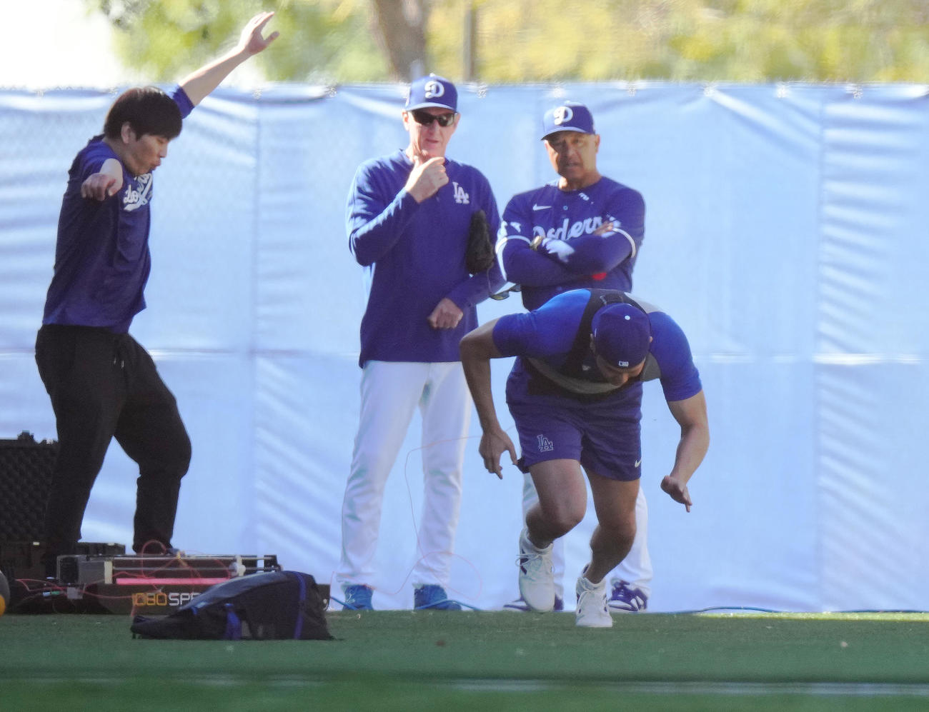 測定器をつけダッシュをするドジャース大谷（手前）は、突然ワイヤが切れてしまい体勢を崩してしまう。後方左から水原通訳、レネキー氏、ロバーツ監督（撮影・菅敏）