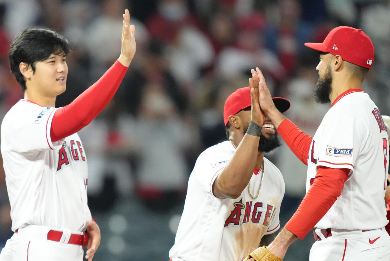 2023年4月、アスレチックスに勝利しフィールドでナインとタッチをする大谷翔平は、アンゾニー・レンドン（右）をお腹を手で防御しながら迎える。中央はもん絶するルイス・レンヒーフォ