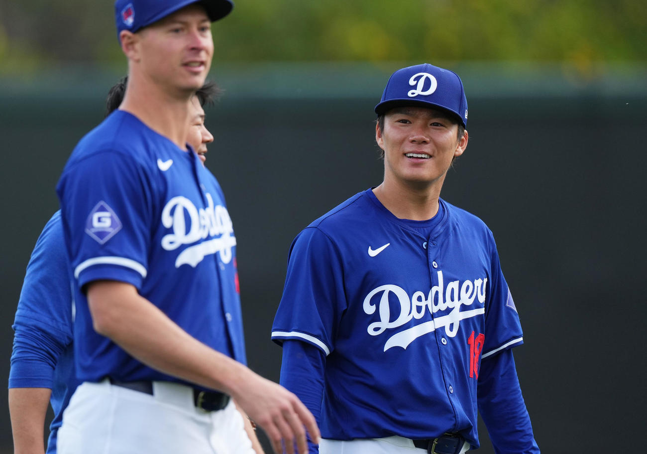 練習メニューを間違えてフィールドに登場した大谷を笑顔で見つめるドジャース山本（右）（撮影・菅敏）