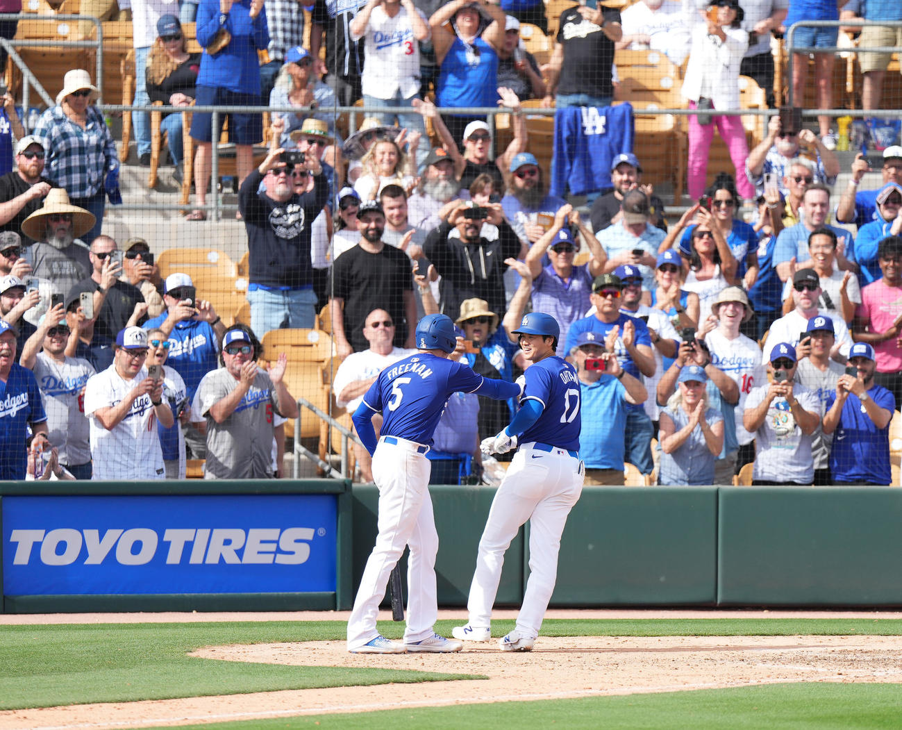 ドジャース対ホワイトソックス　5回裏ドジャース2死二塁、左越えに2点本塁打を放ち、フリーマン（左）にタッチで祝福されるドジャース大谷（撮影・菅敏）