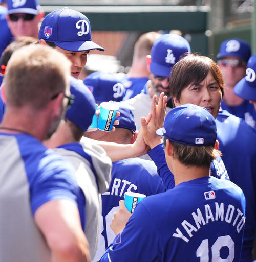 レンジャーズとのオープン戦に初登板し2回を投げ1安打無失点に抑えた山本（手前右）をタッチで迎えるドジャース大谷（後方左）（撮影・菅敏）
