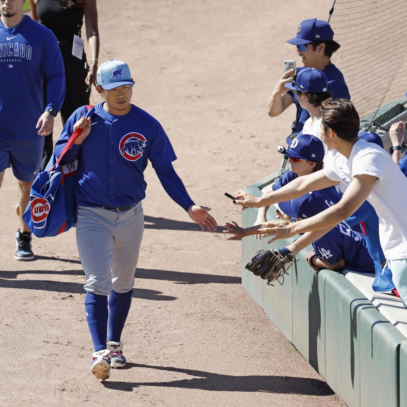 ドジャース戦の登板を終え、ファンとタッチしながら引き揚げるカブス・今永＝グレンデール（共同）
