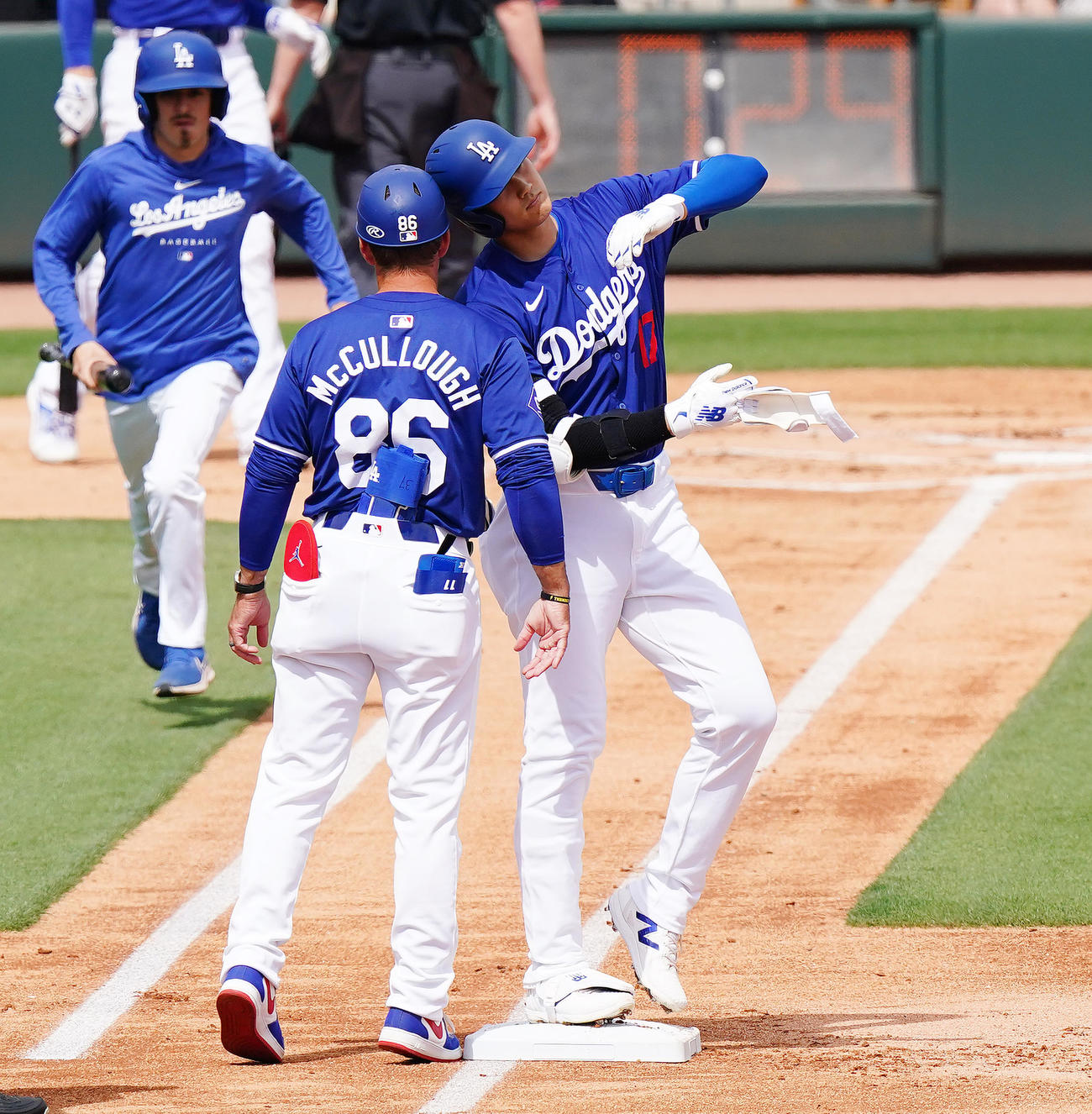 ドジャース対ジャイアンツ　1回裏ドジャース1死、右前打を放ち、一塁走塁コーチとヘルメットでタッチをする大谷（右）（撮影・菅敏）