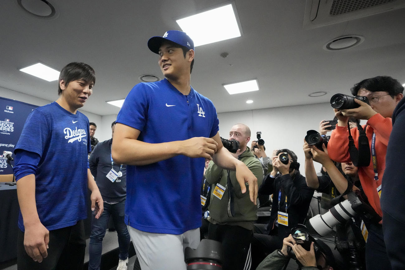 会見場を後にするドジャース大谷翔平（中央）と水原一平通訳（左）（AP）