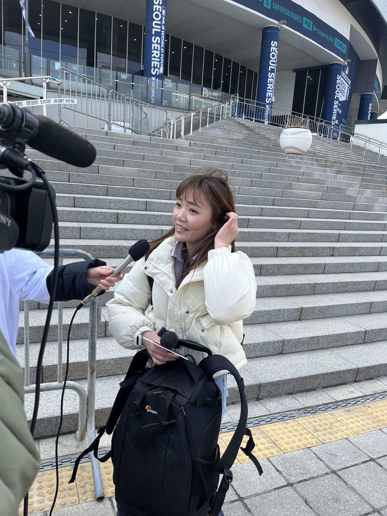 球場前の階段わきに荷物を置いて離れ、戻ってきたら規制線が張られて困惑する台湾メディアだったが、荷物を無事に引き取れてひと安心（撮影・斎藤直樹）