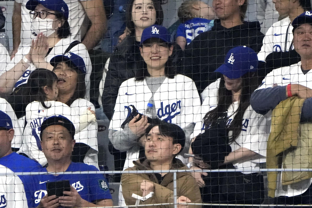 ドジャースのユニホームと帽子を着用し、スタンドから応援する大谷翔平の妻、真美子夫人（中央）（AP）