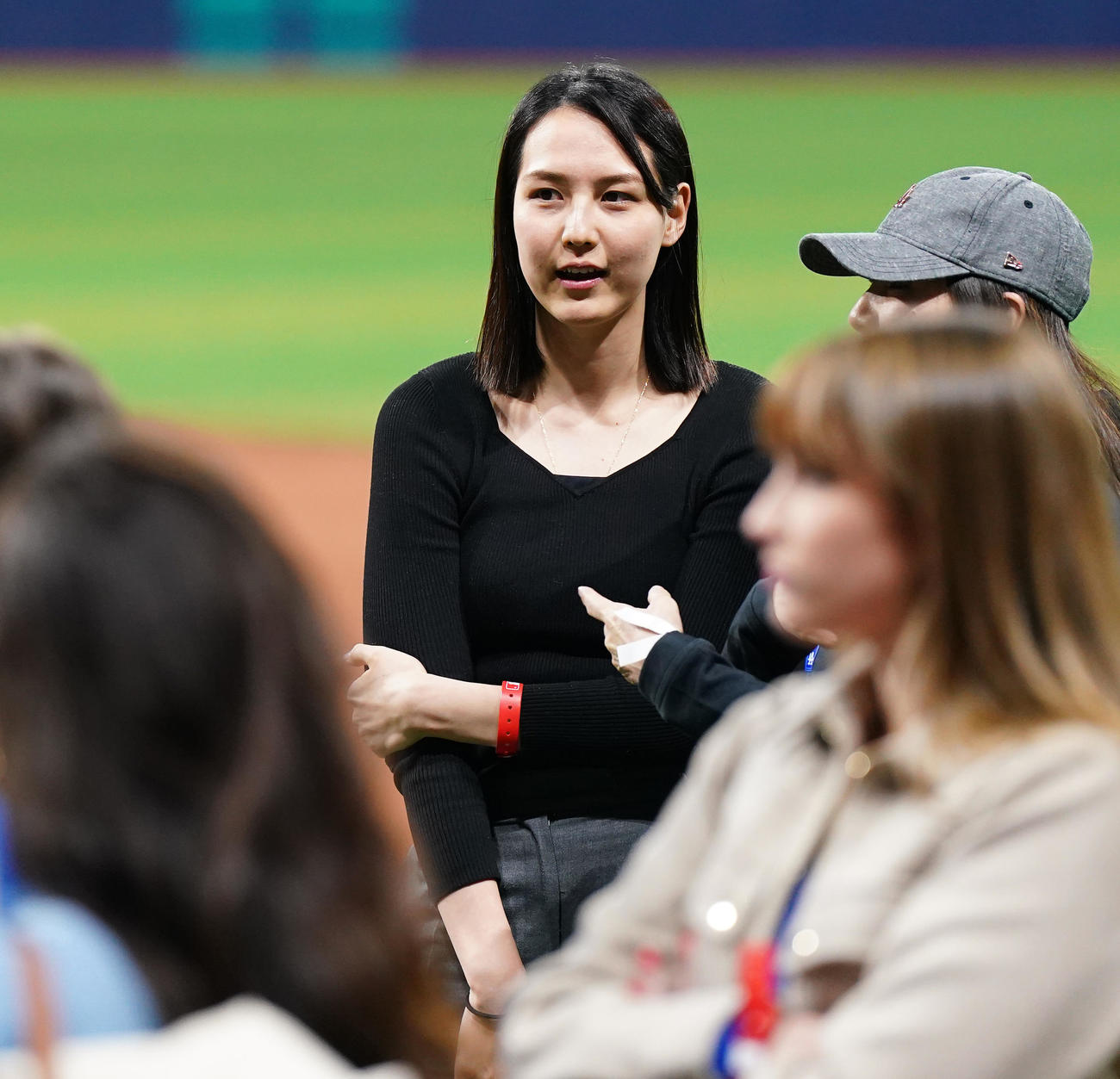 ドジャース対パドレス　試合後にフィールドで関係者と笑顔で話す真美子夫人（左）（撮影・菅敏）